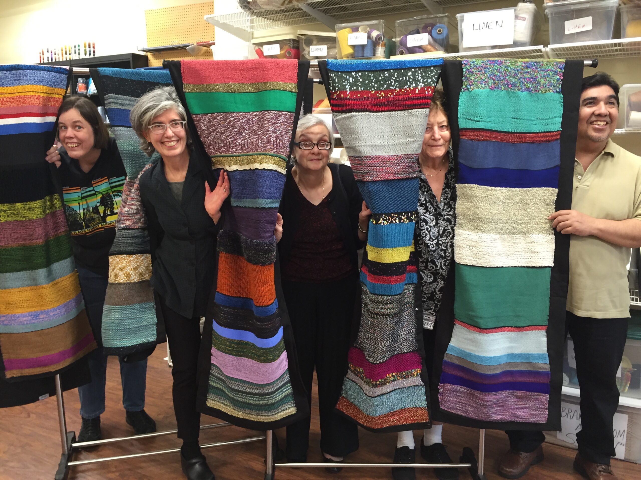 Residents and staff with hand-woven tapestries