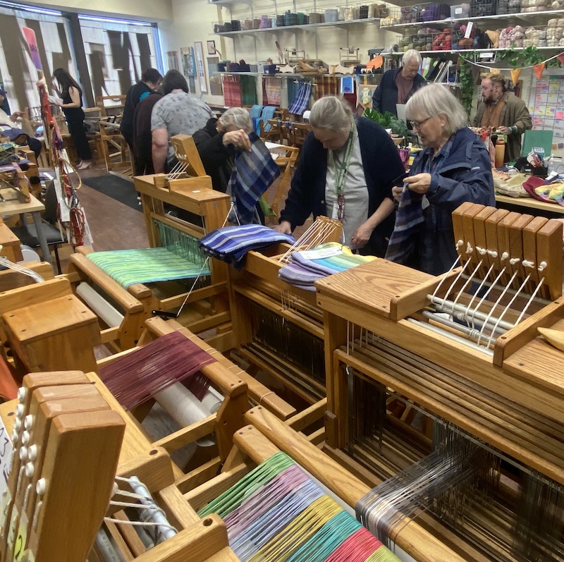 A group of visitors look at woven goods in the Therapeutic Weaving Studio during the annual Open House and Art Show.